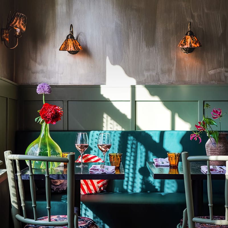 The green room in Vreeland with its wall lamps and blue banquette