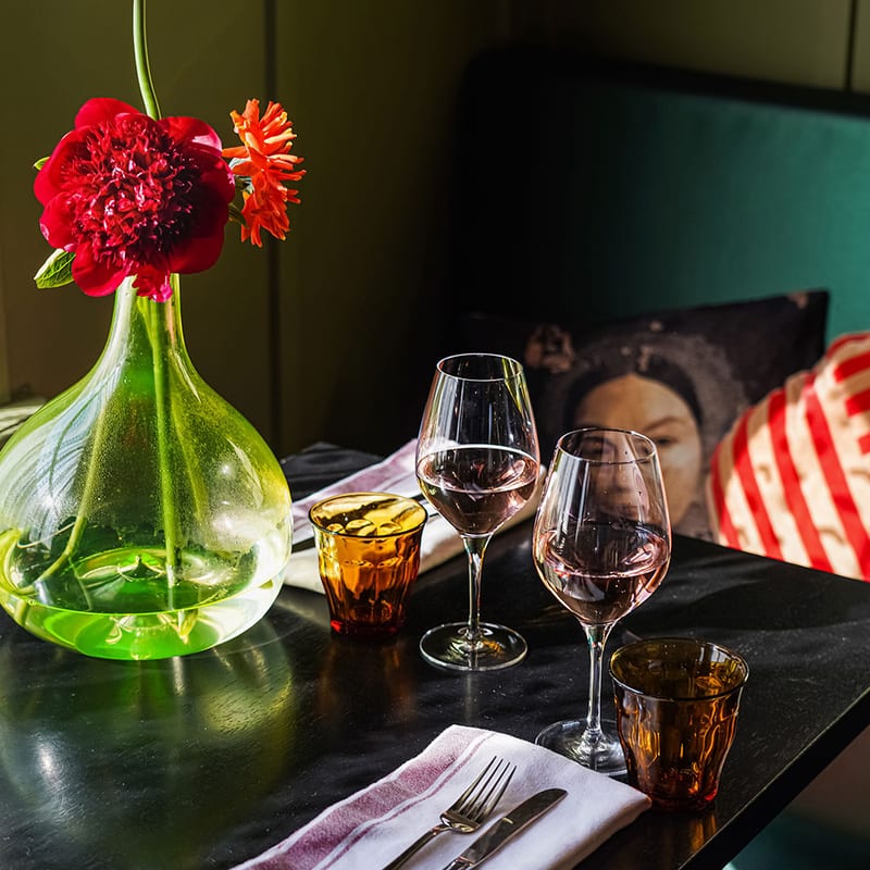 Wine glasses and a green carafe on the table