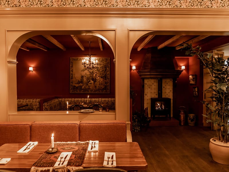 The banquette under the arch, with candles and a tapestry