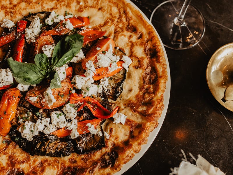 Een pannenkoek met geitenkaas, paprika en basilicum