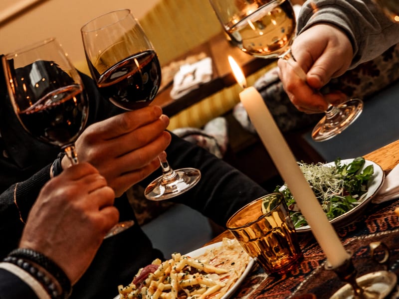 Guests raising a glass by candlelight
