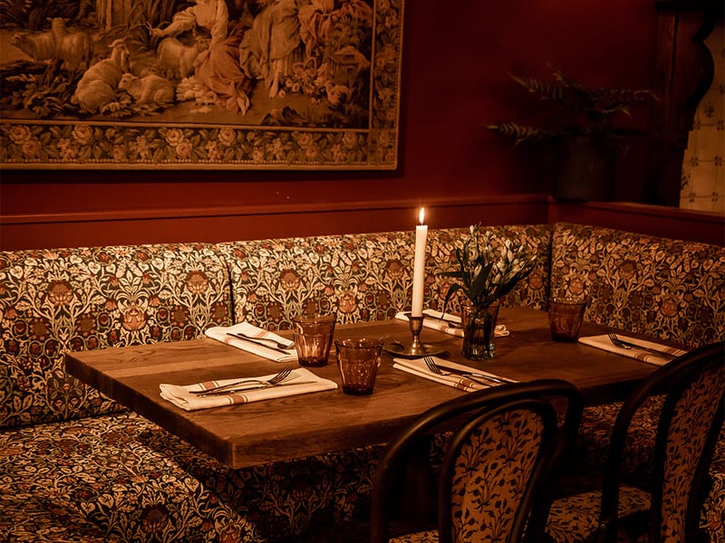 Een gedekte tafel met glazen in de lichte zaal