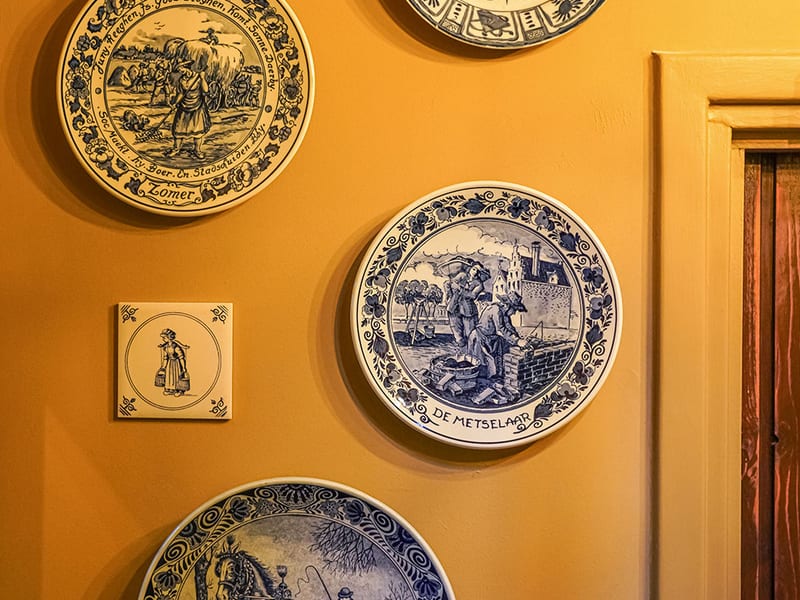 Delft blue plates on an ochre wall