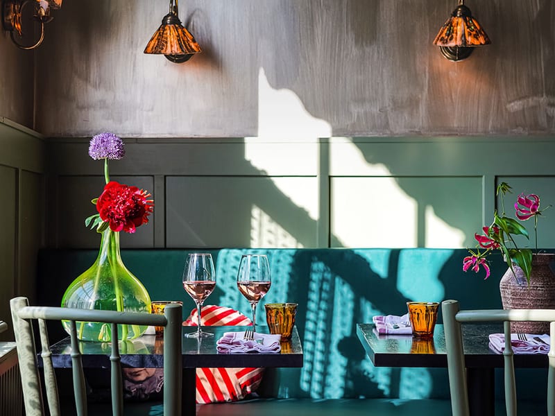 The green room with Tiffany lamps and a turquoise banquette