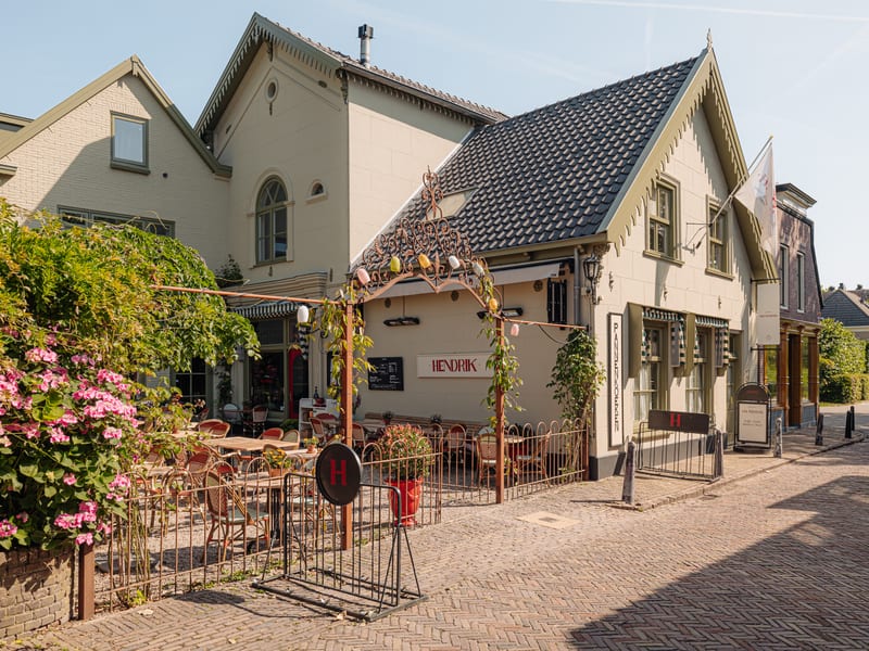 Het koetshuis aan de Breedstraat met het terras en de stokrozen