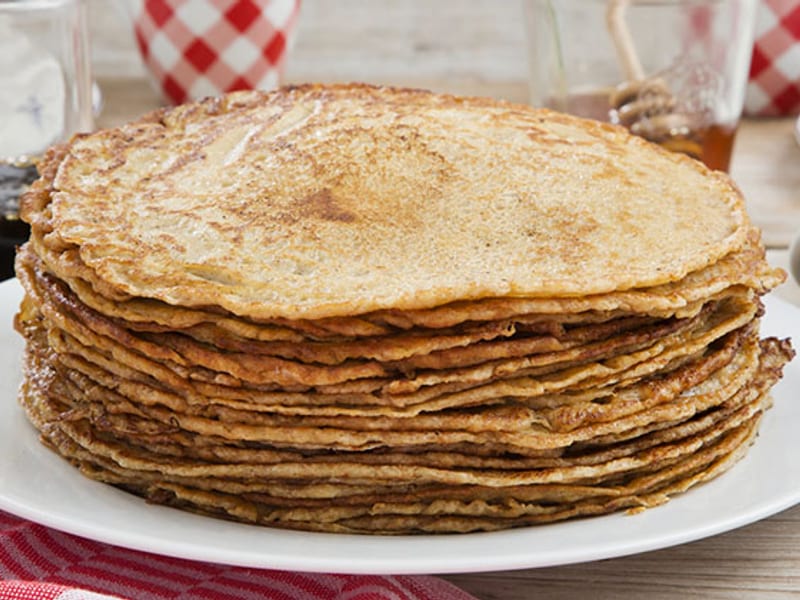 A stack of handmade pancakes on a checked cloth